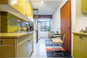 a kitchen with yellow cabinets and a table and chairs at Casa Jardim by LovelyStay in Porto