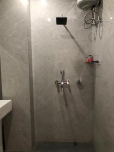 a shower with a faucet in a bathroom at Anne’s Laces Homestay in Guwahati