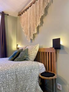 - une chambre avec un lit et un ordinateur portable sur le mur dans l'établissement Les Logis Aux portes de la Vallée de Chevreuse, 