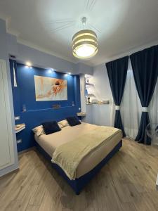 1 dormitorio con 1 cama con pared azul en Ambramarina B&B, en Nettuno