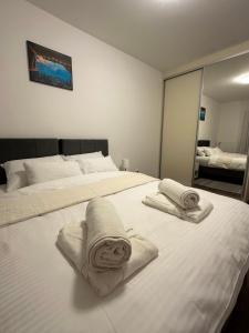 a bedroom with two white towels on a bed at Vila Drina Apartments in Banja Koviljača