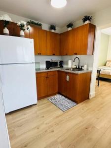 a kitchen with a white refrigerator and wooden cabinets at Miami Coral Gables Studio near Airport and Beaches in Miami