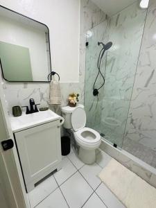 a bathroom with a shower and a toilet and a sink at Miami Coral Gables Studio near Airport and Beaches in Miami