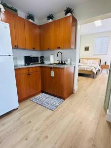 a kitchen with wooden cabinets and a white refrigerator at Miami Coral Gables Studio near Airport and Beaches in Miami