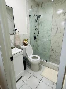 a bathroom with a toilet and a glass shower at Miami Coral Gables Studio near Airport and Beaches in Miami