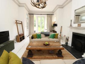 a living room with a couch and a coffee table at Grand Victorian family home - nestled between woodland and beach in Haven Street