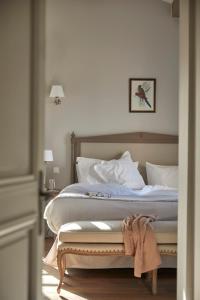 a bedroom with a large bed with white sheets at Château Capitoul in Narbonne