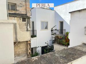 a white building with a sign that reads pera at Residence Lori in Brindisi