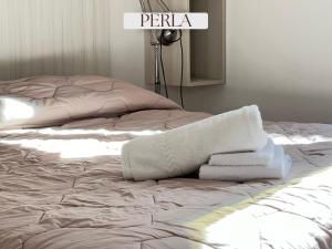 an unmade bed with towels on top of it at Residence Lori in Brindisi
