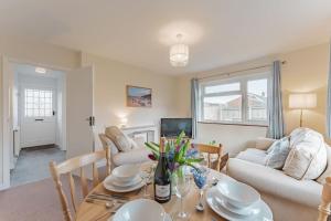 - un salon avec une table, des chaises et un canapé dans l'établissement Coast Haven - Norfolk Cottage Agency, à Sheringham