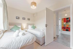 - 2 lits dans une chambre aux murs blancs dans l'établissement Coast Haven - Norfolk Cottage Agency, à Sheringham