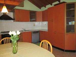 a kitchen with a table with a vase of flowers on it at La Casa del Borgo in Brissago Valtravaglia