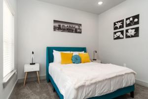 Un dormitorio con una cama azul y blanca con almohadas amarillas en Corporate Housing by MGM, en Grand Prairie