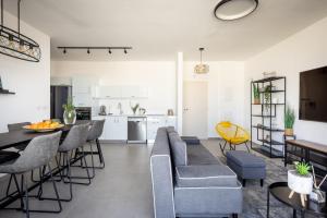 特拉維夫的住宿－HaCarmel Market Vibrat Apartment by Sea N' Rent，客厅以及带沙发和椅子的厨房。