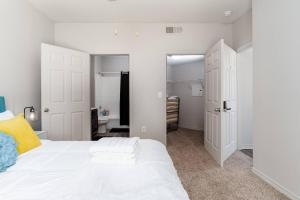 1 dormitorio con cama blanca y armario en Affordable 2BR Farmers Branch en Farmers Branch