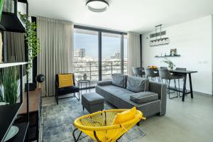 a living room with a couch and a table at HaCarmel Market Vibrat Apartment by Sea N' Rent in Tel Aviv