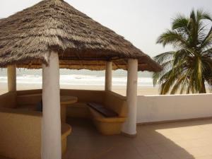 HOTEL DU BAR DE LA MER CAP SKIRRiNG في Kabrousse: كوخ على الشاطئ مع نخلة