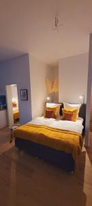 um quarto com uma cama grande com lençóis e almofadas amarelos em RüWellnessSuite I Rü-Stern I Messe I Klinikum em Essen