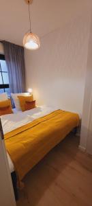 a bedroom with a large bed with a yellow blanket at RüWellnessSuite I Rü-Stern I Messe I Klinikum in Essen