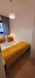 um quarto com uma cama grande e um cobertor amarelo em RüWellnessSuite I Rü-Stern I Messe I Klinikum em Essen