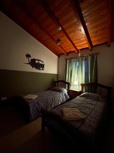 een slaapkamer met 2 bedden en een raam bij Don Hugo in Villa Giardino