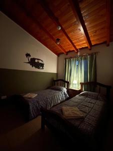 a bedroom with two beds and a window at Don Hugo in Villa Giardino