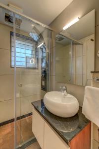 a bathroom with a sink and a glass shower at HARI GOVINDA'S in Mysore