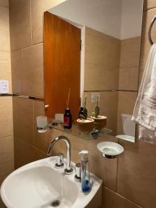 een badkamer met een wastafel en een spiegel bij Don Hugo in Villa Giardino