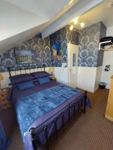 um quarto com uma cama grande num quarto com papel de parede em Westfield House em Blackpool