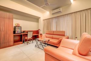 ein Wohnzimmer mit einem Sofa und einem Tisch in der Unterkunft HARI GOVINDA'S in Mysore