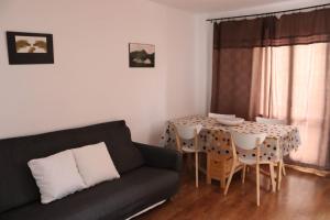a living room with a couch and a table with chairs at Apartamento Boltaña en Margudgued in Margudgued