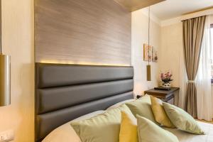 a bedroom with a bed with a black headboard at Warmthotel in Rome
