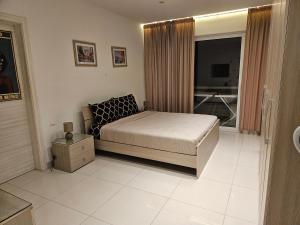sypialnia z łóżkiem oraz łazienka z telewizorem w obiekcie Luxury Waterfront Apartment w mieście Mellieħa