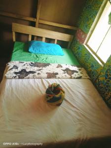 a bed with a hat sitting on top of it at Tanna Eagle twin volcano view tree house in White Sands