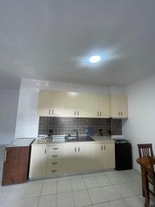 a kitchen with white cabinets and a sink at Gega Apartment in Shkodër