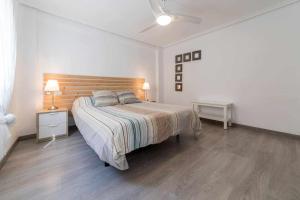 Schlafzimmer mit einem großen Bett mit einem Kopfteil aus Holz in der Unterkunft Piso Carolina in Valencia
