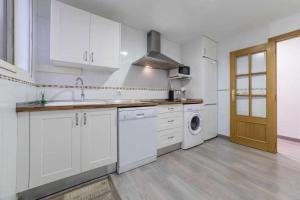 a kitchen with white cabinets and a washer and dryer at Piso Carolina in Valencia