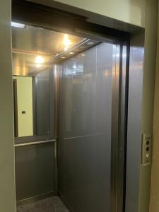 a glass shower door in a bathroom with a mirror at Gega Apartment in Shkodër