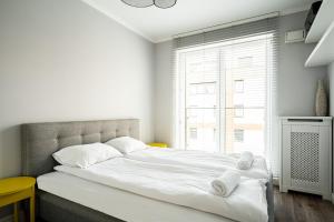 ein weißes Schlafzimmer mit einem großen Bett mit Handtüchern darauf in der Unterkunft RentPlanet - Apartament Dubois in Breslau