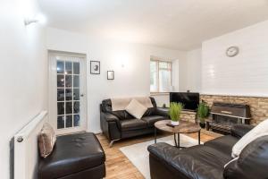 uma sala de estar com mobiliário de couro e uma lareira em May Disc - Long Stay - Contractors em Swindon