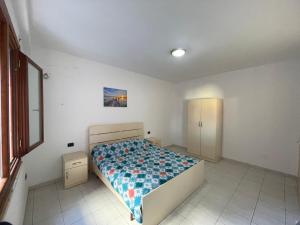 a bedroom with a bed with a blue comforter at Gega Apartment in Shkodër