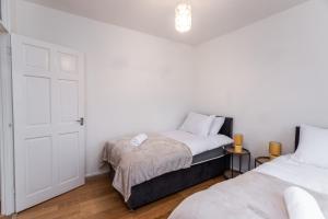 um quarto com 2 camas e uma porta branca em May Disc - Long Stay - Contractors em Swindon