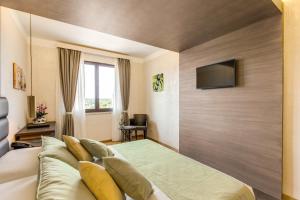 a bedroom with a large bed and a flat screen tv at Warmthotel in Rome