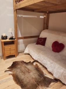 1 dormitorio con 1 cama con manta blanca y almohadas rojas en Le Nid des Cerfs, en Essert-Romand