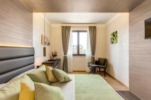 a bedroom with a bed and a desk and a window at Warmthotel in Rome