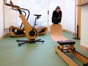 uma mulher em pé em um ginásio com vários equipamentos de exercício em Logis Hôtel de l'Europe em Poitiers