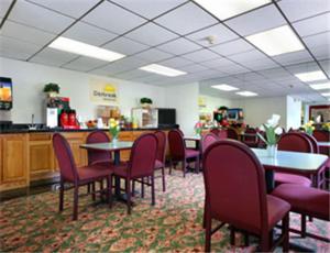 a dining room with tables and chairs in a restaurant at Travelodge by Wyndham Waukegan Gurnee in Waukegan