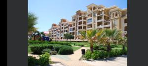 un gran edificio de apartamentos con palmeras y arbustos en Primera línea de playa en Canela Park, en Isla Canela