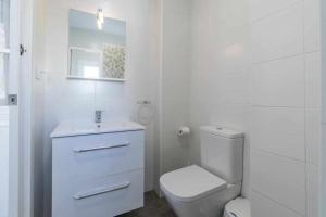 a white bathroom with a toilet and a sink at Piso Visitacion in Valencia