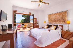 a bedroom with a bed and a desk and a television at Villa Cab - Cala Vinyas in Cala Vinyes